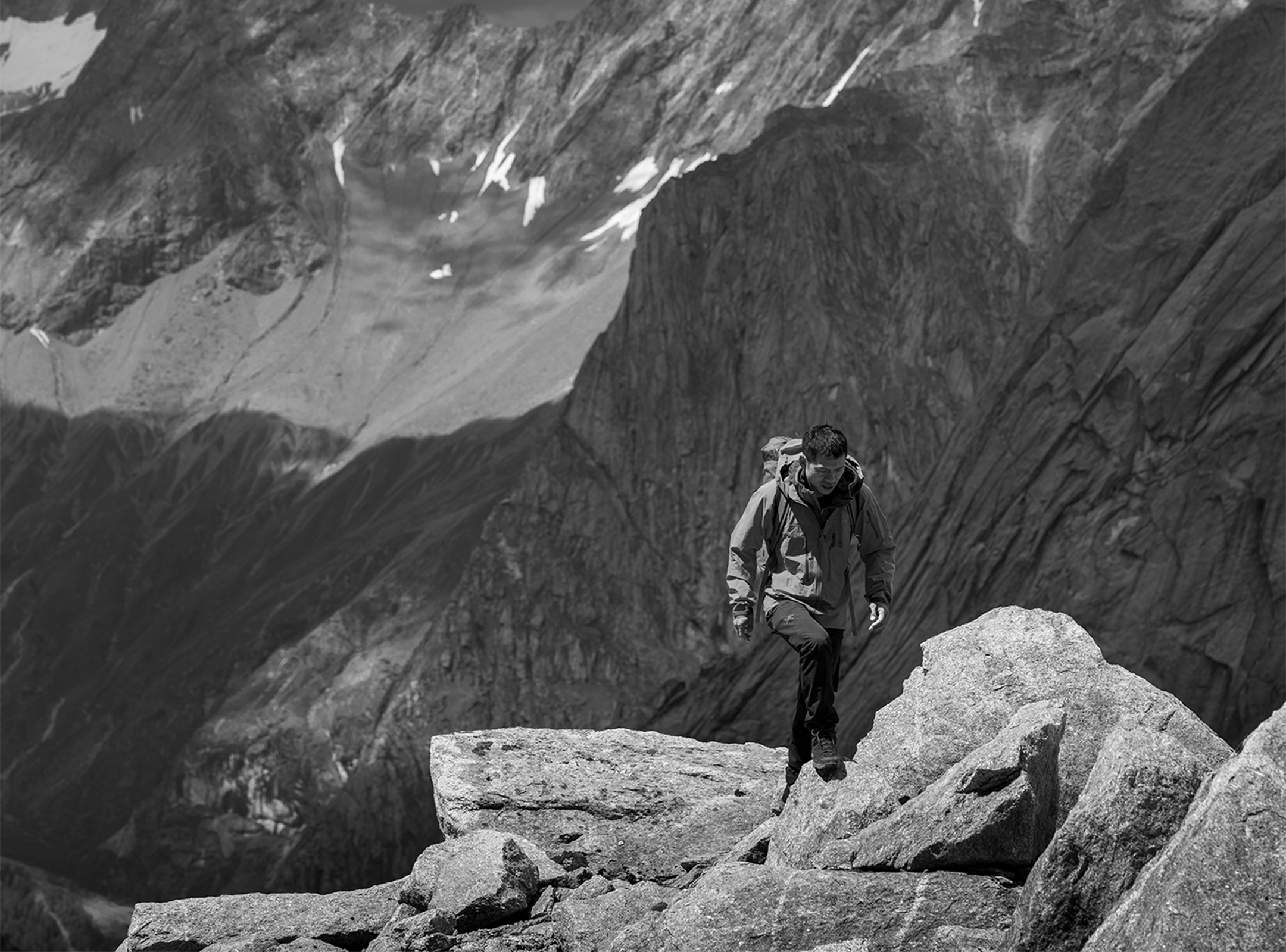 Arcteryx - Man walking up steep mountain ridge