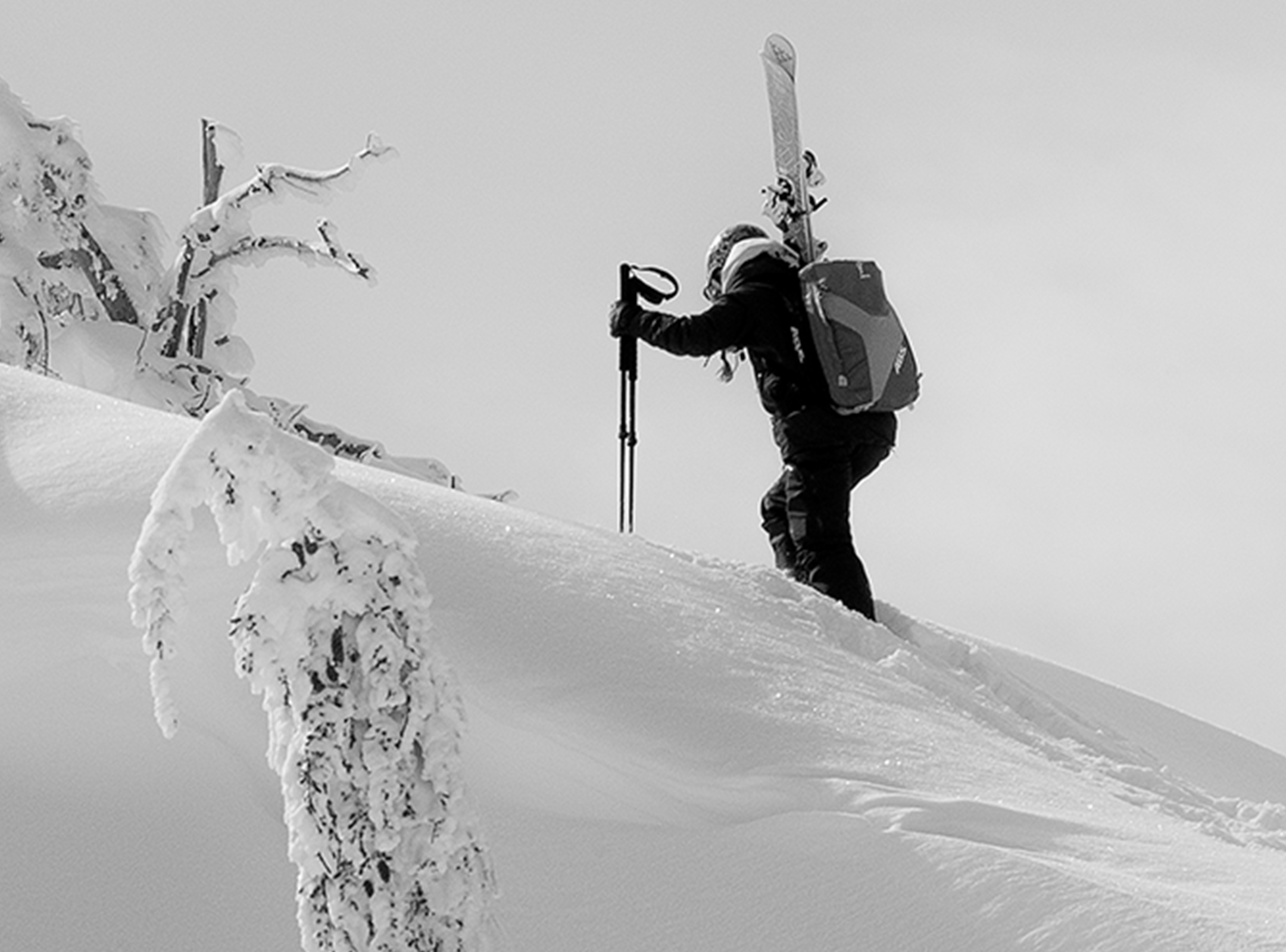 Arcteryx - Woman climbing up steep mountain ridge with skis